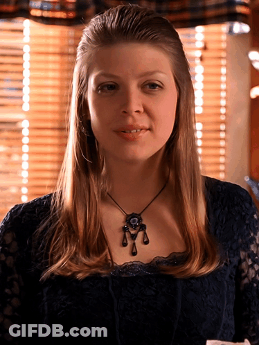 Woman In Black Lace Top And Necklace Smiling GIF