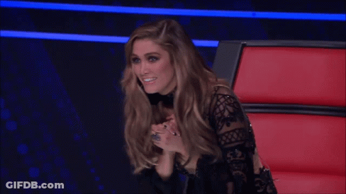 Woman In Black Lace Top Smiling In Red Chair GIF