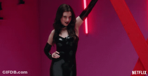 Woman In Black Latex Outfit Standing In Front Of Red Pole With Netflix GIF