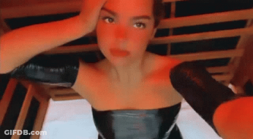 Woman In Black Leather Dress Taking Selfie In Sauna GIF