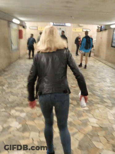Woman In Black Leather Jacket Approaching Ascensoare Sign GIF