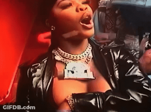Woman In Black Leather Jacket With Dollar Sign Necklace GIF
