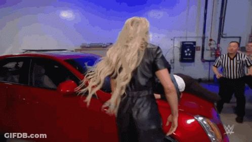 Woman In Black Leather Jumpsuit In Front Of Red Car GIF