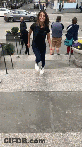Woman In Black Nike Shirt Walking Down Stairs GIF