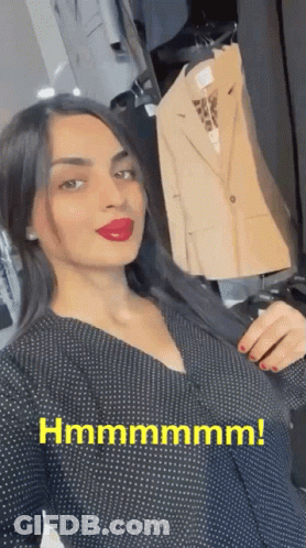 Woman In Black Polka Dot Dress Holding Jacket Beside Hanger Hmmmmmm GIF