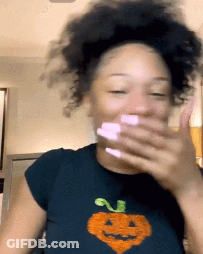 Woman In Black Pumpkin T-Shirt Covering Mouth GIF