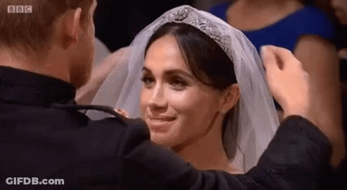 Woman In Black Shirt And Necklace Looking At Camera GIF