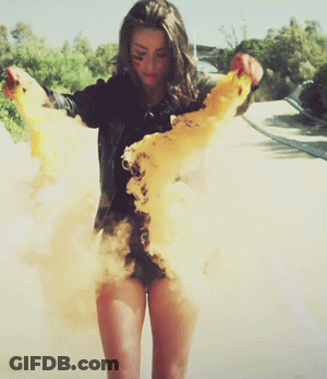 Woman In Black Shirt And Shorts Standing In Dust Cloud GIF