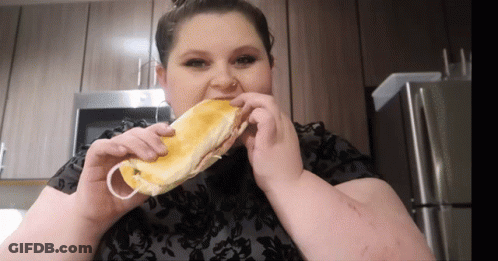 Woman In Black Shirt Eating Sandwich GIF