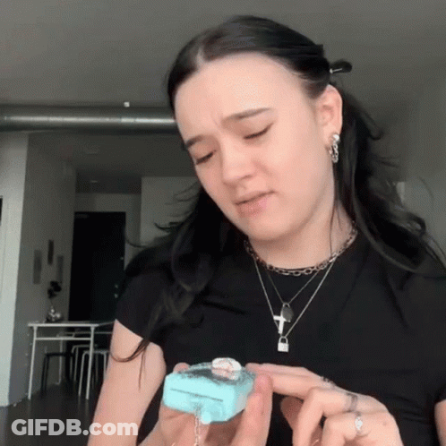 Woman In Black Shirt Holding Blue Item GIF