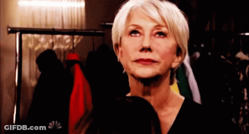 Woman In Black Shirt In Front Of Clothes Rack GIF