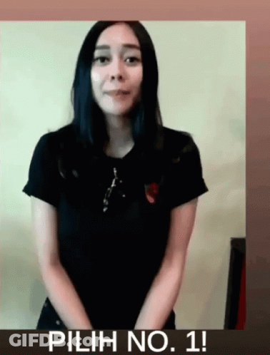 Woman In Black Shirt In Front Of Pilih No. 1 Sign GIF