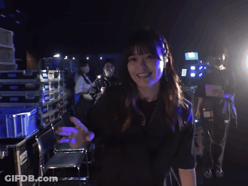 Woman In Black Shirt Smiling And Waving GIF