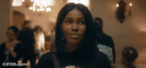 Woman In Black Shirt With Crown Looking At Camera GIF