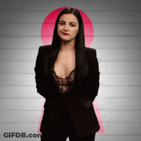 Woman In Black Suit And Lace Bra In Front Of Pink Keyhole GIF