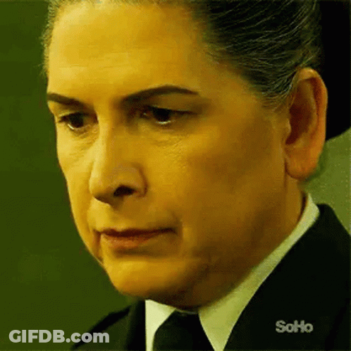 Woman In Black Suit And Tie Looking At Camera GIF