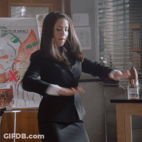 Woman In Black Suit Dancing Before Points Of Impact Board GIF