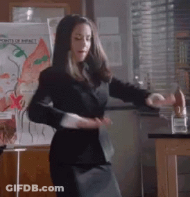 Woman In Black Suit Dancing Before Points Of Impact Board GIF