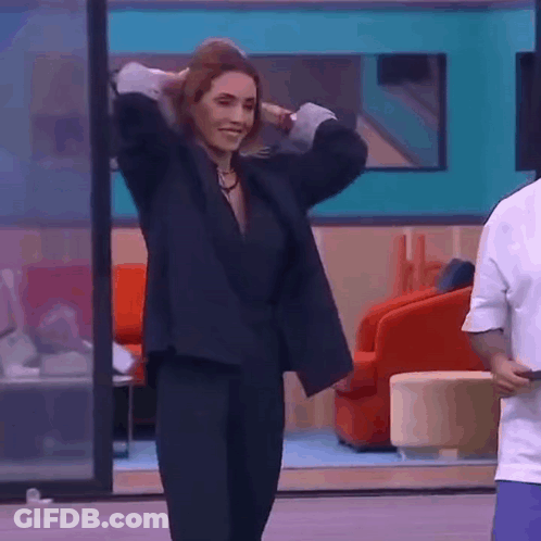 Woman In Black Suit Dancing With Man Behind Her GIF