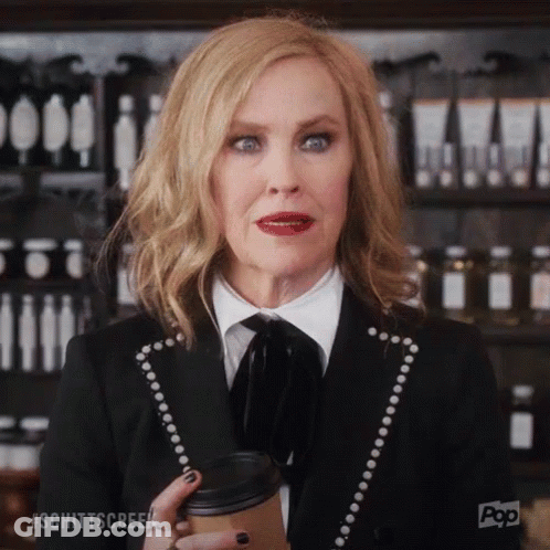 Woman In Black Suit Holding Coffee GIF