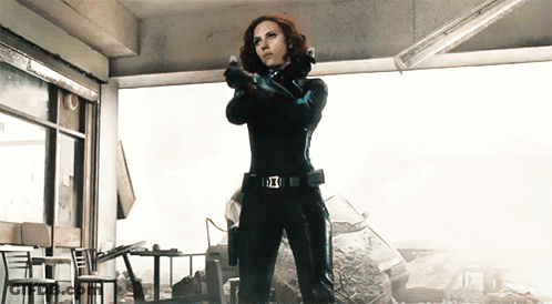 Woman In Black Suit Holding Gun With Avengers Belt GIF