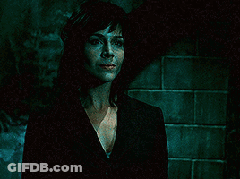 Woman In Black Suit In Dark Room GIF
