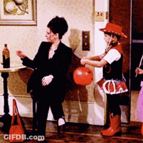 Woman In Black Suit Next To Girl In Red Hat GIF