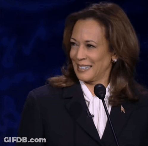 Woman In Black Suit Smiling At Microphone GIF