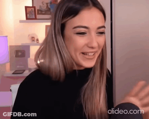 Woman In Black Sweater Smiling At Camera Clideo.com GIF
