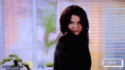 Woman In Black Sweater Smiling At Camera GIF
