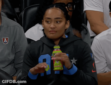 Woman In Black Sweatshirt With Letter A Holding Green Bottle GIF