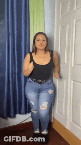 Woman In Black Tank Top And Blue Jeans Standing In Room GIF