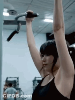 Woman In Black Tank Top Hanging On Gym Bar GIF