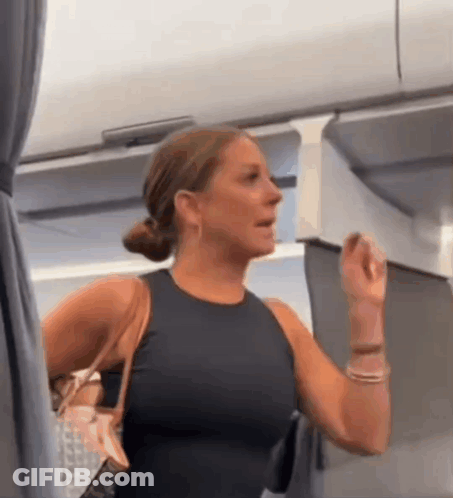 Woman In Black Tank Top Holding Purse In Airplane GIF