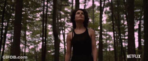 Woman In Black Tank Top In Forest With Netflix GIF