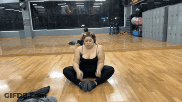 Woman In Black Tank Top Sitting In Front Of Gym Mirror GIF