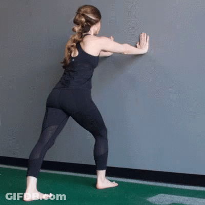Woman In Black Tank Top Sitting On Gym Floor In Front Of Mirror GIF