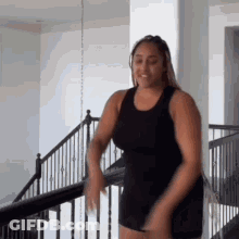 Woman In Black Tank Top Standing On Staircase GIF
