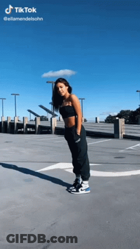 Woman In Black Top And Black Pants In Parking Lot GIF