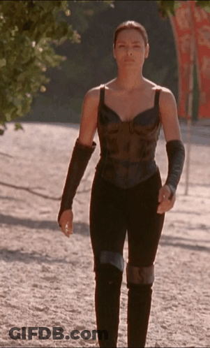 Woman In Black Top And Pants Walking Down Dirt Path GIF