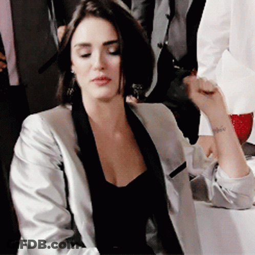 Woman In Black Top And Silver Jacket With Wrist Tattoo GIF