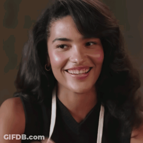 Woman In Black Top And White Apron Smiling GIF