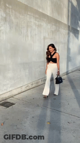 Woman In Black Top And White Pants Walking GIF