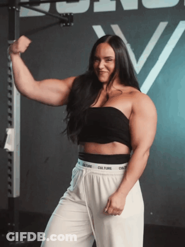 Woman In Black Top And White Pants With Culture Waistband GIF