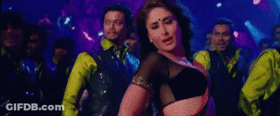 Woman In Black Top Dancing In Front Of Men In Yellow Shirts GIF