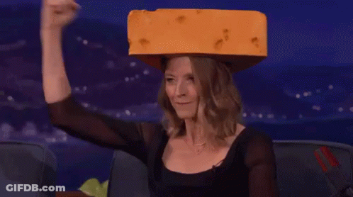 Woman In Black Top Holding Cheese On Head GIF