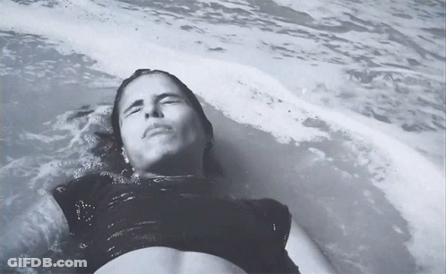 Woman In Black Top Lying In Water GIF