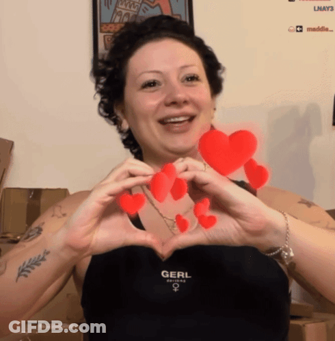 Woman In Black Top Saying Gerl Making Heart Shape GIF