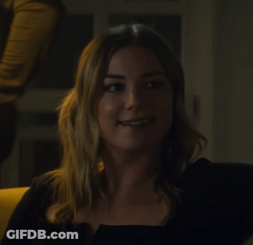 Woman In Black Top Smiling Looking To Side GIF