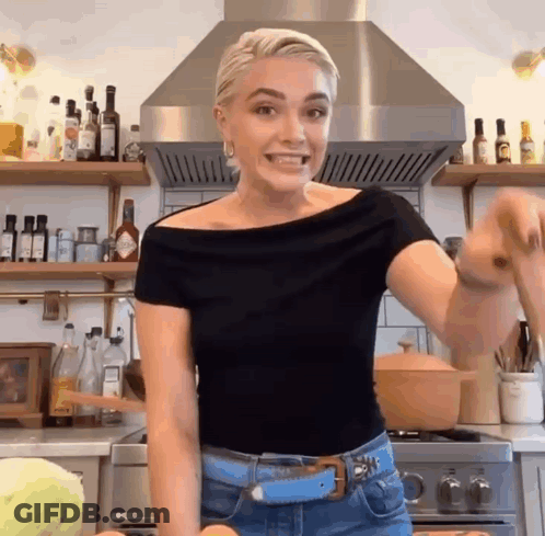 Woman In Black Top With Pot In Kitchen GIF
